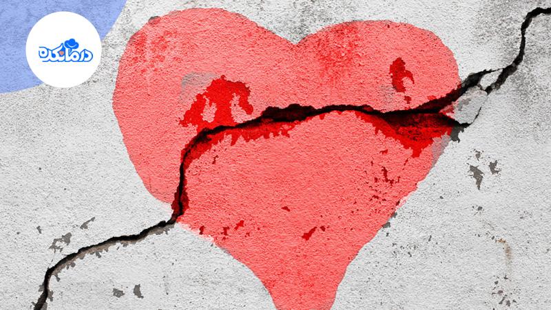 تصویر نقاشی قلب روی دیوار سیمانی را نشان می‌دهد. نقاشی قلب درست در قسمت ترک دیوار قرار دارد و شکستگی قلب را تداعی می‌کند