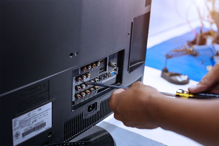 تعمیر کار مشغول تعمیر تلویزیون